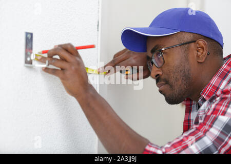 man measuring a wall using a folding ruler Stock Photo