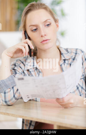 young female carpenter using a smartphone while assembling a furniture Stock Photo