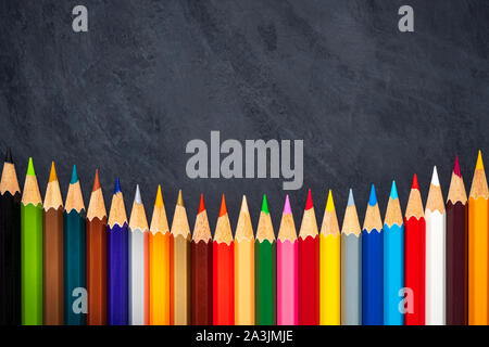 Colored pencils on chalkboard background. Top view and copy space. Concept of art education. Stock Photo