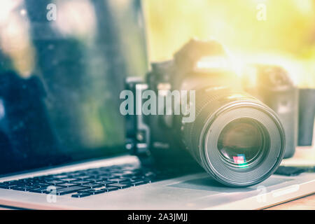 Digital Photography Workstation. Modern Digital DSLR Camera, Laptop Computer and Display. Stock Photo