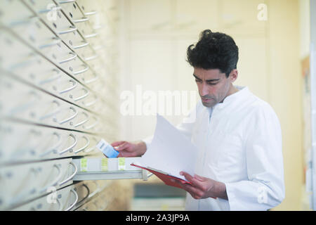 pharmacist in a pharmacy with a tablet Stock Photo