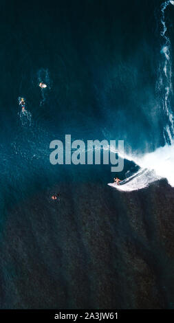 Surfer riding a wave from drone view Stock Photo