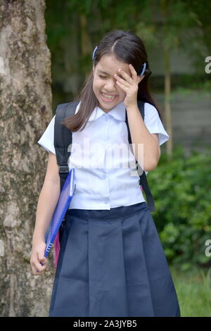 Tearful School Girl Wearing School Uniform With Notebooks Stock Photo