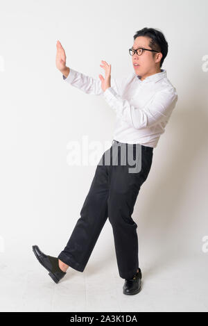 Portrait of stressed young Asian businessman with eyeglasses running away Stock Photo