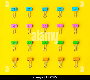 Colorful paper clips on a yellow background Stock Photo