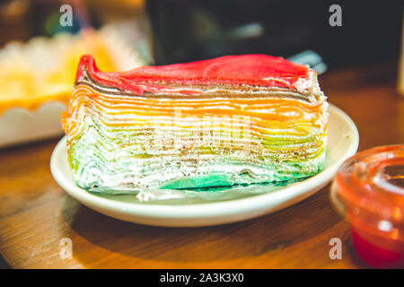 Layer cheesecake colourful rainbow sweet dessert with dipping coating top Stock Photo