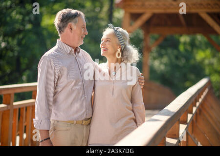 Grey-haired husband hugging his tender beautiful wife Stock Photo