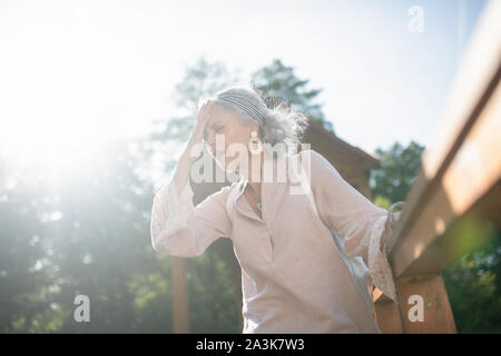 Low angle of woman feeling awful suffering from headache Stock Photo