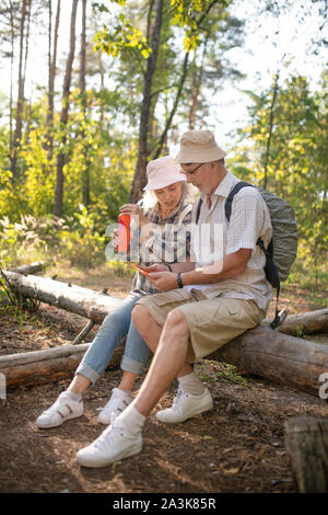 Tourists having little break while walking in national park together Stock Photo