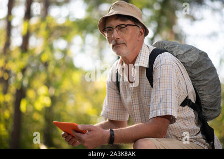 Bearded man wearing backpack enjoying hiking in national park Stock Photo