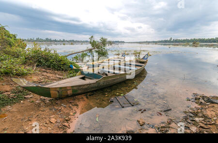 Old dirty boat on lake river shore on gloomy rainy day Stock Photo