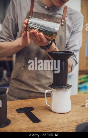 Barista puts coffee in aeropress. Alternative making coffee Stock Photo