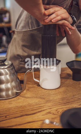 Barista pushing coffee in an aeropress. Alternative method. Stock Photo