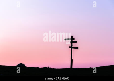 21/8-19, Mugarra, Pais vasco, Spain. A lonely  wooden signpost with three signs in different directions silhouetted against a beautiful sunset sky. Stock Photo
