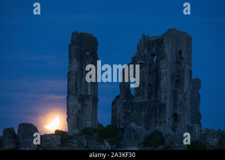 The partially eclipsed moon over Corfe Castle, Dorset, England, UK Stock Photo