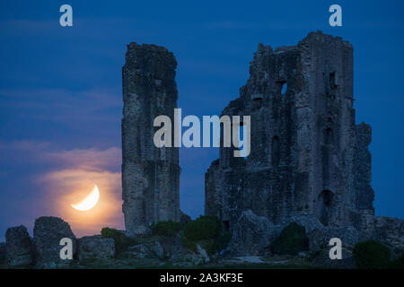 The partially eclipsed moon over Corfe Castle, Dorset, England, UK Stock Photo