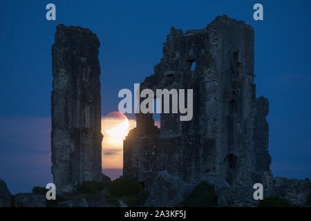 The partially eclipsed moon over Corfe Castle, Dorset, England, UK Stock Photo