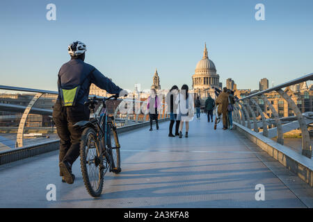 Pedestrians walking over the Millenium Bridge with St Paul's Cathedral beyond, London, England, UK Stock Photo