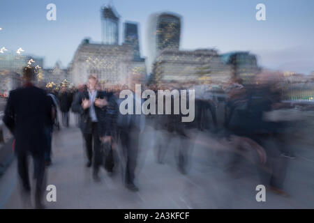 Commuters on London Bridge at dusk, London, England, UK Stock Photo