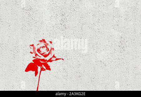 Single red rose made in graffiti style with stencil effect painted on white washed wall. Landscape format with blank copy space. Stock Photo