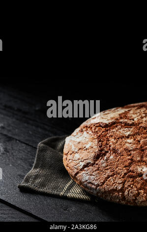 Freshly baked bread on black wooden background. Copy space. Selective focus. Stock Photo