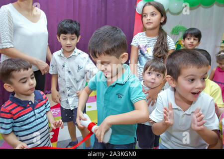 Birthday two years in the kindergarden . Children's birthday with animators . Happy group of children at a birthday celebration dressed in the style Stock Photo