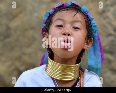 Little Myanmarese Kayan Lahwi girl with tribal brass neck rings/coils sticks out her tongue. Stock Photo