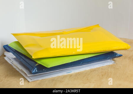 Stack of colorful data folders on the office wooden table. Office workplace. Copy space. Stock Photo