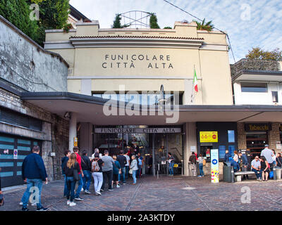 Line of people queuing to take the cable car to the upper town of Bergamo Stock Photo