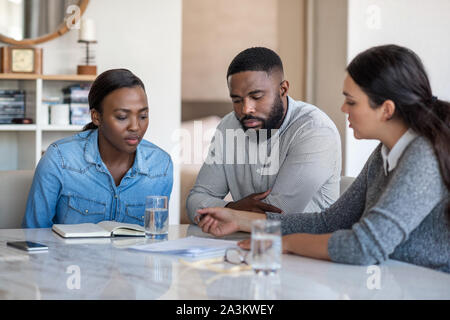 Financial planner going over documents with an African American couple Stock Photo