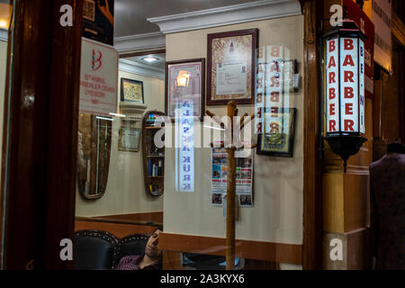 Istanbul: man sleeping on a chair in a barber shop inside the Cicek Pasaji, the Flower Passage, historic galleria on Istiklal Caddesi, a famous avenue Stock Photo