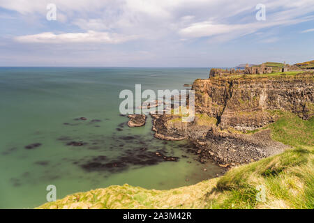 Early morning sunlight over Dunluce Castle at the Causeway Coast of Northern Ireland