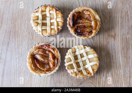 Homemade apple pies on a wooden table in a kitchen Stock Photo