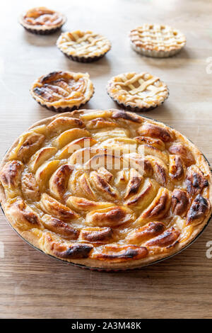 Homemade apple pies on a wooden table in a kitchen Stock Photo