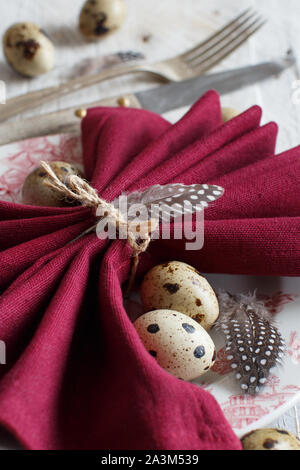 Easter table setting with quail eggs and feathers Stock Photo
