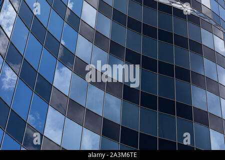 Curved glass building facade with sky reflection Stock Photo