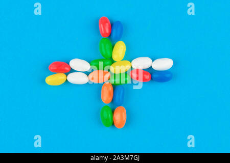 multi colored candies on a blue background. Tasty colorful candies on blue background. Flat lay. Stock Photo
