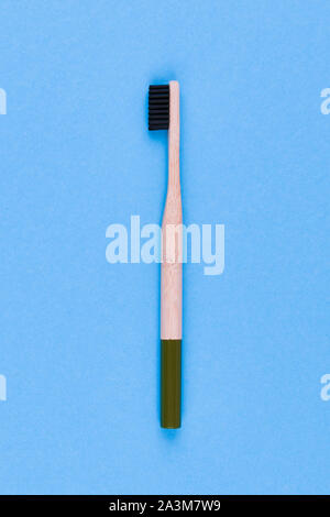 wooden toothbrush on a blue background. Close up wooden toothbrush on a blue background. eco brush. Stock Photo