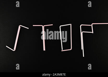 Stop plastic. made of plastic the word stop. The word STOP made of plastic tubes on a black background with empty space for text. View from above. Stock Photo