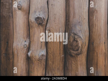 Wooden wall from logs of pine as a background texture. logs are arranged vertically. a wooden palisade Stock Photo