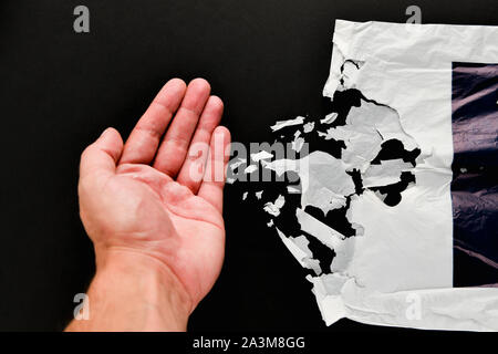 bag on a black background. decaying polyethylene. Caring for the environment.  Stock Photo