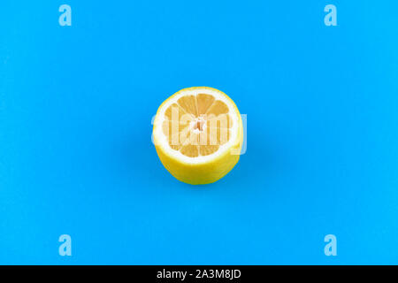 lemon on a blue background. half cut lemon. view from above. place to write. Lemon slices on a blue background. In summer, cool slices of orange Stock Photo