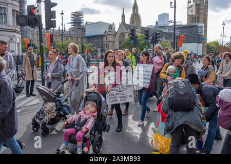 Whitehall, London, UK. 9th October 2019. Large police presence makes arrests and removes Extinction Rebellion activists who have glues themselves to Whitehall. A Mothers March attempts to join the activists in Whitehall, arriving from Parliament Square, but are blocked by police. Credit: Malcolm Park/Alamy Live News. Stock Photo