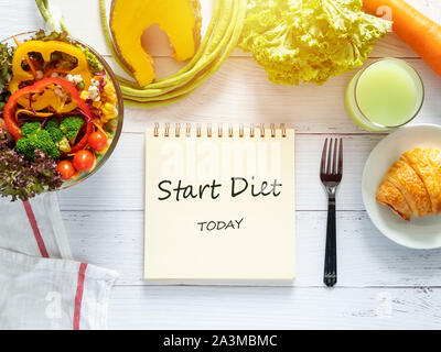 healthy eating, dieting, slimming and weight loss goals concept. target of diet plan on paper with salad bowl, fresh vegetable , fruit juice on dining Stock Photo