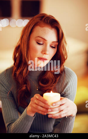 Portrait of millennial woman holding candle at home Stock Photo