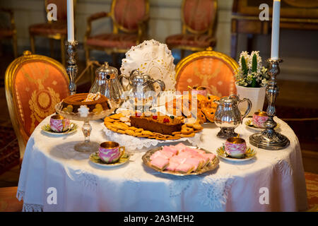 Beautiful Christmas classic table setting with traditional Finnish treats. Tea set, coffee pot and pastries. Stock Photo