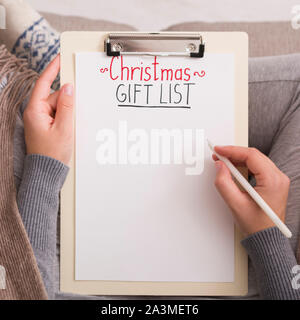Close up of woman writing Christmas gift list for big family Stock Photo