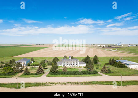 Historic white estate home in rural america, large expansive fields and blue sky Stock Photo