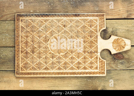 Wooden cutting board handmade crafted on rough rural table, rustic retro style, flat lay, overhead top view, closeup, empty space for your design Stock Photo