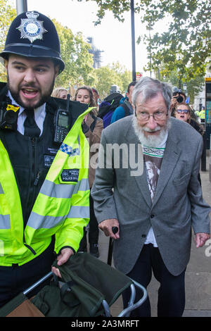 London, UK. 9 October, 2019. John Lynes, a 91-year-old climate activist from Extinction Rebellion is arrested by police officers using Section 14 of the Public Order Act 1986 after blocking Whitehall on the third day of International Rebellion protests to demand a government declaration of a climate and ecological emergency, a commitment to halting biodiversity loss and net zero carbon emissions by 2025 and for the government to create and be led by the decisions of a Citizens’ Assembly on climate and ecological justice. Credit: Mark Kerrison/Alamy Live News